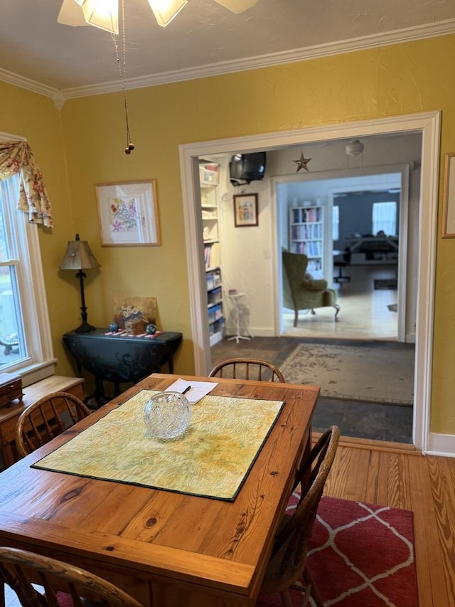 dining space featuring hardwood / wood-style floors, ceiling fan, and ornamental molding