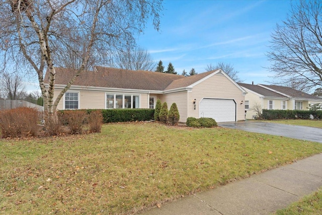 ranch-style home featuring a garage and a front lawn