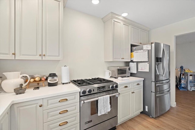 kitchen featuring white cabinets, appliances with stainless steel finishes, and light hardwood / wood-style flooring