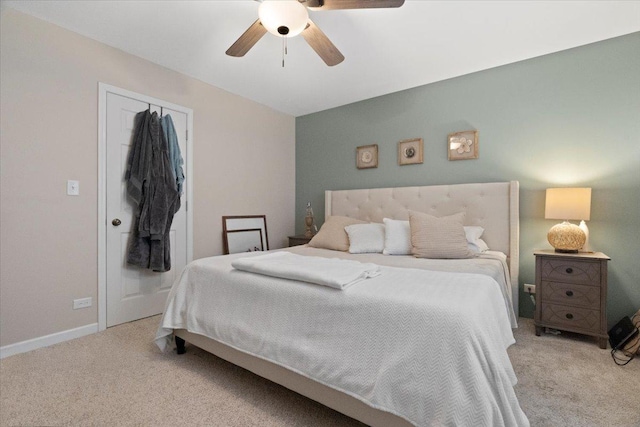 carpeted bedroom with ceiling fan and a closet