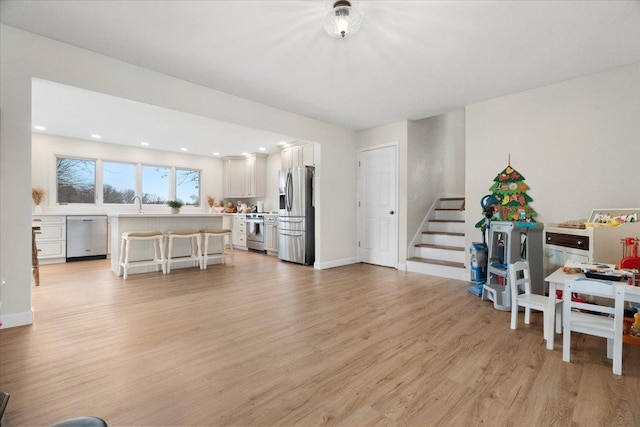 living room featuring sink and light hardwood / wood-style floors