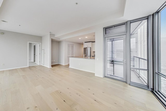 unfurnished living room featuring plenty of natural light and light wood-type flooring