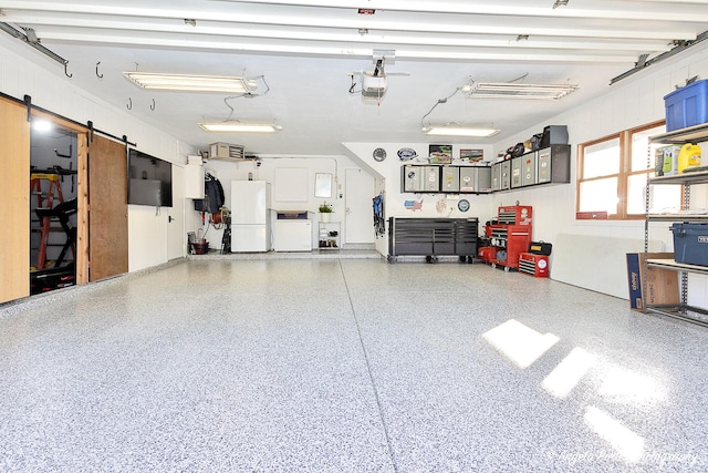 garage featuring washing machine and clothes dryer and white fridge