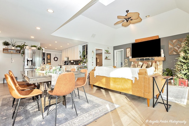 dining area featuring ceiling fan, light hardwood / wood-style floors, and vaulted ceiling