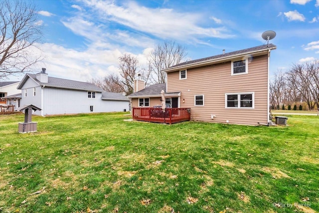 rear view of property featuring a yard, cooling unit, and a wooden deck