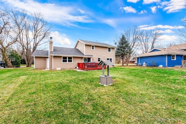 rear view of house with a yard and a wooden deck