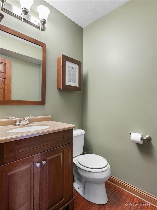 bathroom featuring hardwood / wood-style flooring, vanity, and toilet