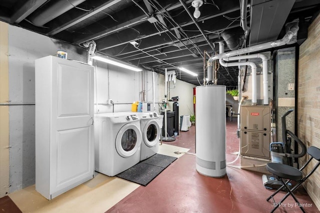 clothes washing area featuring separate washer and dryer and water heater