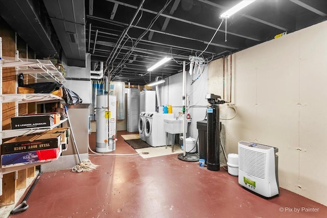 basement with water heater, sink, and washing machine and clothes dryer