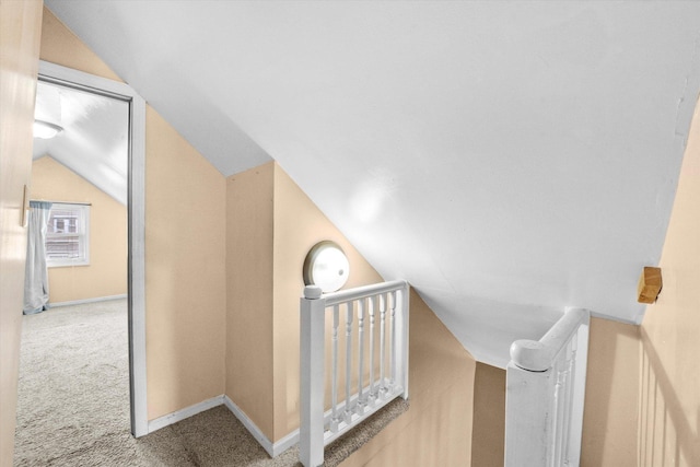 corridor featuring carpet flooring and vaulted ceiling