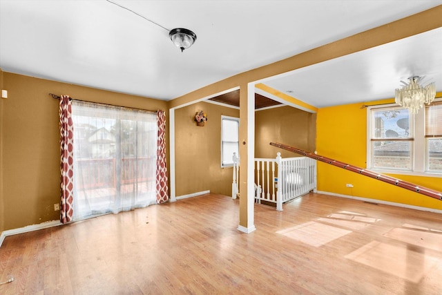 unfurnished room with a notable chandelier and wood-type flooring