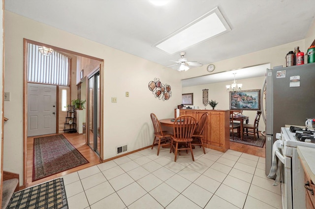 dining room featuring ceiling fan with notable chandelier and light wood-type flooring