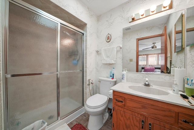 bathroom featuring vanity, toilet, walk in shower, and ceiling fan