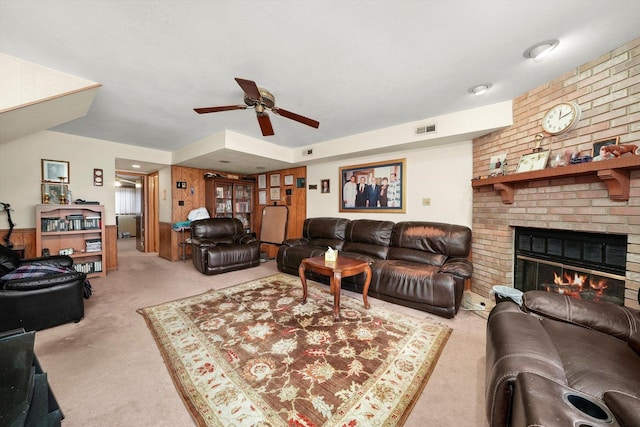 carpeted living room with ceiling fan and a fireplace