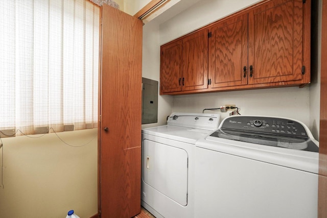 laundry room with washer and clothes dryer, cabinets, and electric panel