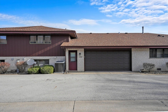 tri-level home featuring central AC and a garage