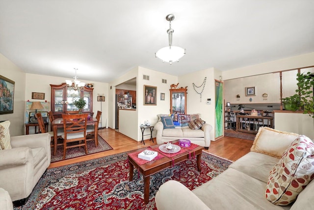 living room with light hardwood / wood-style flooring and a chandelier