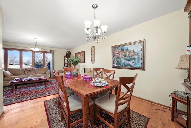 dining space featuring an inviting chandelier and light wood-type flooring