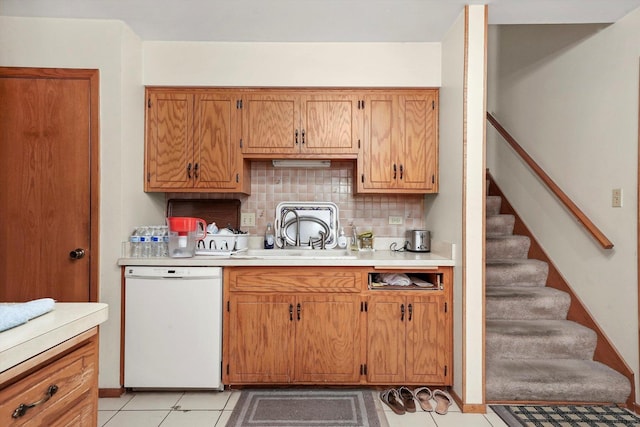 kitchen with backsplash, sink, white dishwasher, and light tile patterned flooring