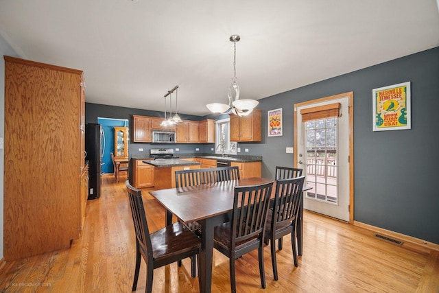 dining space with light wood-type flooring and sink