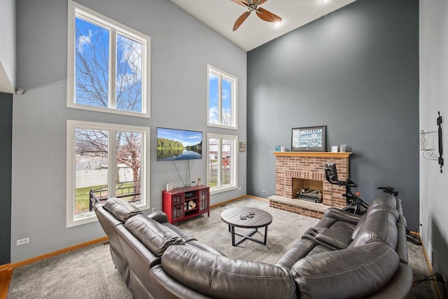 carpeted living room featuring high vaulted ceiling, a brick fireplace, and ceiling fan