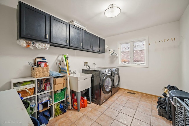 laundry area featuring cabinets, washing machine and dryer, and light tile patterned floors