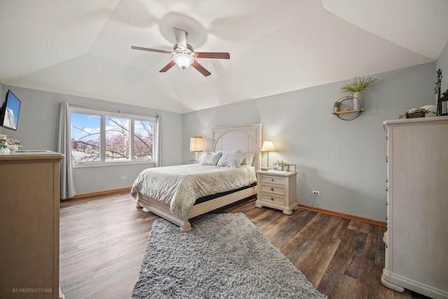 bedroom featuring lofted ceiling, dark hardwood / wood-style floors, ceiling fan, and a raised ceiling