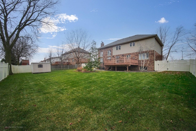 rear view of house with a deck, a yard, and a shed