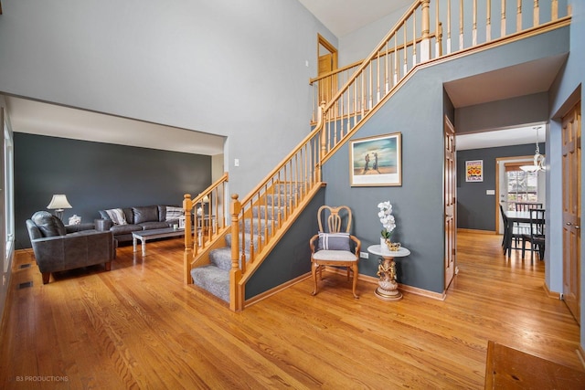 stairway with a chandelier, a high ceiling, and hardwood / wood-style floors