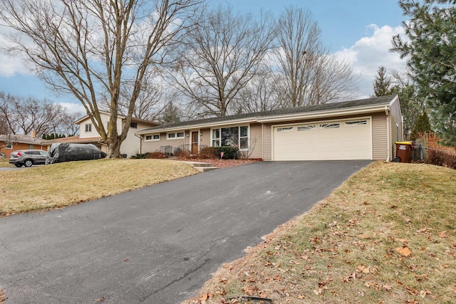 ranch-style home with a garage and a front lawn