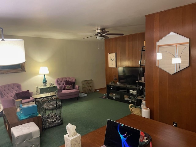 carpeted living room featuring ceiling fan and wooden walls