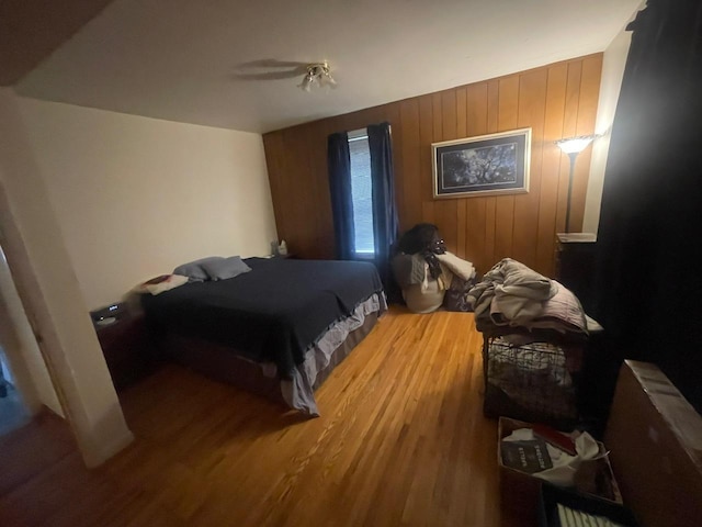 bedroom featuring hardwood / wood-style floors and wooden walls