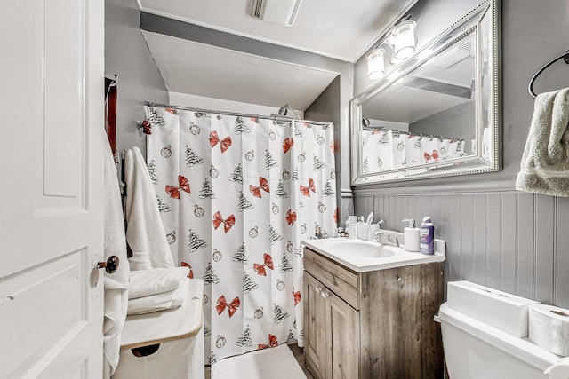 bathroom with walk in shower, vanity, and toilet