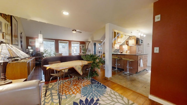 living room featuring ceiling fan, hardwood / wood-style floors, and lofted ceiling