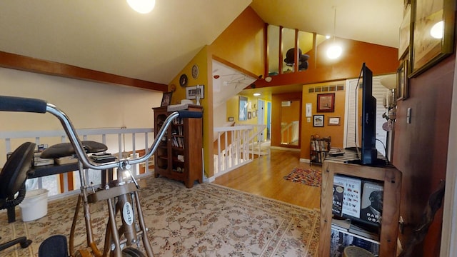 exercise area with hardwood / wood-style floors and high vaulted ceiling