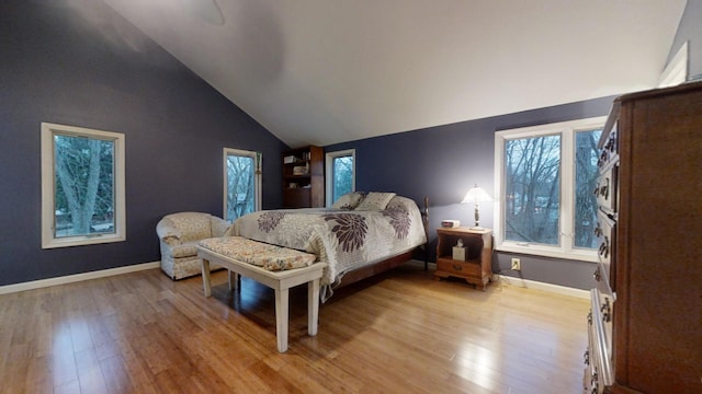 bedroom with high vaulted ceiling and light hardwood / wood-style flooring