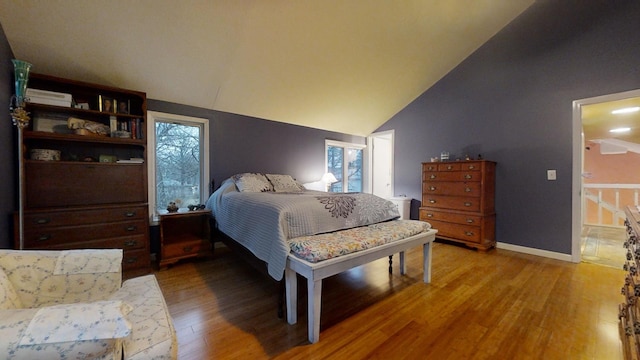 bedroom with hardwood / wood-style flooring and lofted ceiling