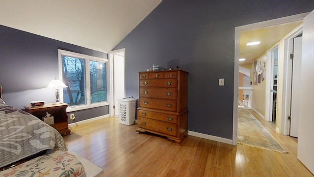 bedroom featuring light hardwood / wood-style flooring and lofted ceiling