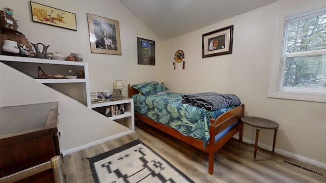 bedroom featuring hardwood / wood-style floors and vaulted ceiling