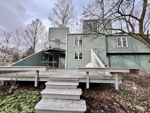 back of house with a balcony and a wooden deck