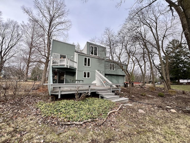 back of property with a balcony and a wooden deck