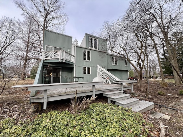 rear view of property featuring a balcony and a deck