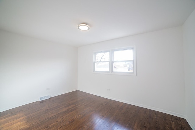 empty room with dark hardwood / wood-style flooring