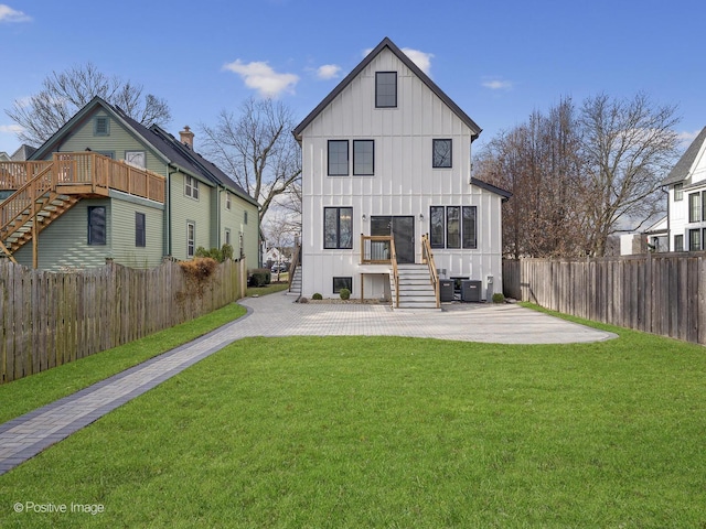 back of house with a patio, a lawn, and central AC