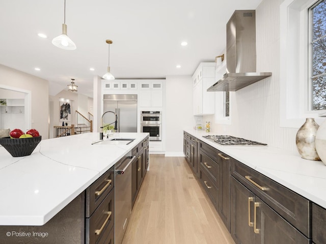 kitchen with appliances with stainless steel finishes, extractor fan, hanging light fixtures, white cabinets, and sink