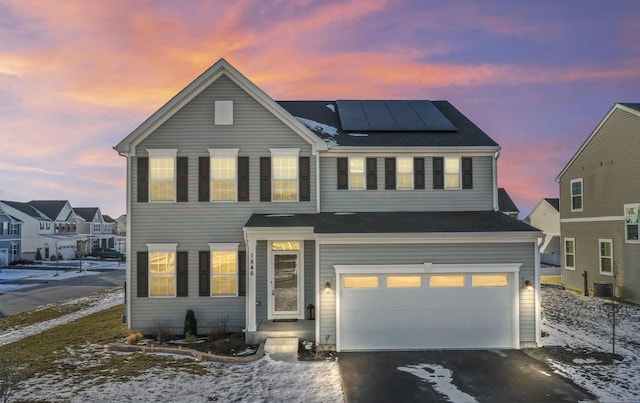 view of front of home featuring solar panels and a garage