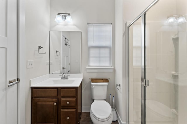 bathroom with toilet, an enclosed shower, and vanity