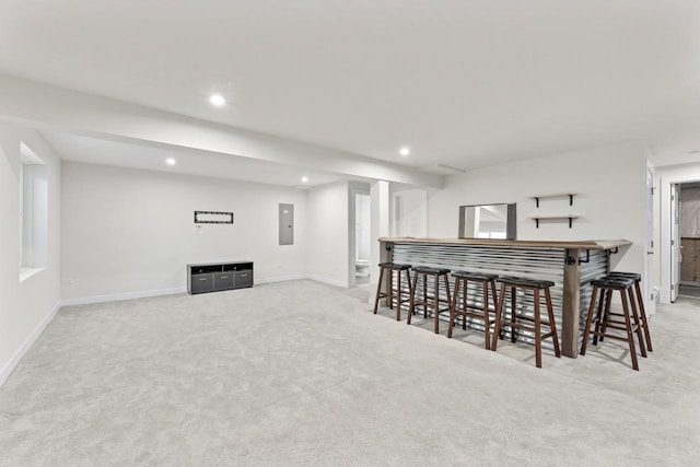 carpeted dining room featuring bar and electric panel