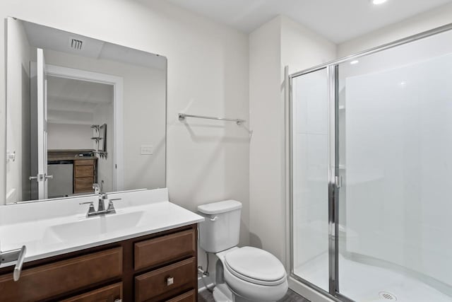 bathroom featuring toilet, vanity, and a shower with shower door