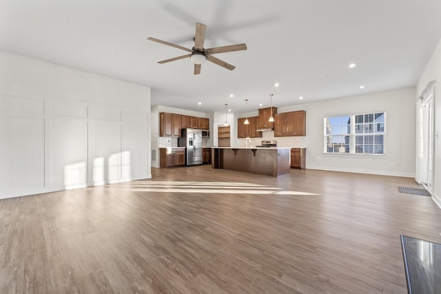 unfurnished living room featuring sink, ceiling fan, and dark hardwood / wood-style floors